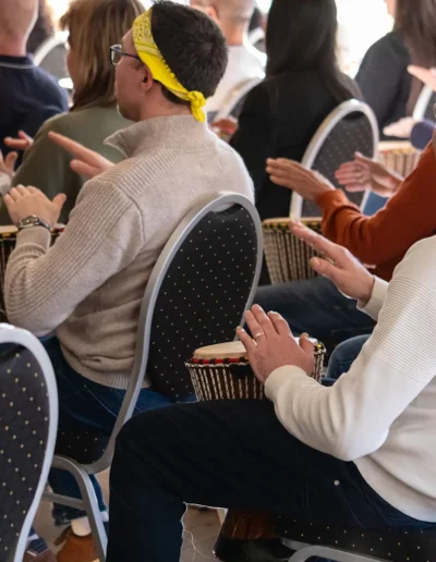 Des participants qui jouent au djembé dans un amphithéâtre