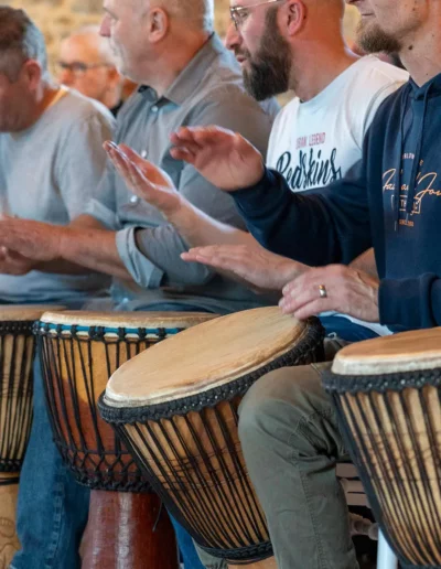 Des participants qui jouent au djembé tous en ensemble